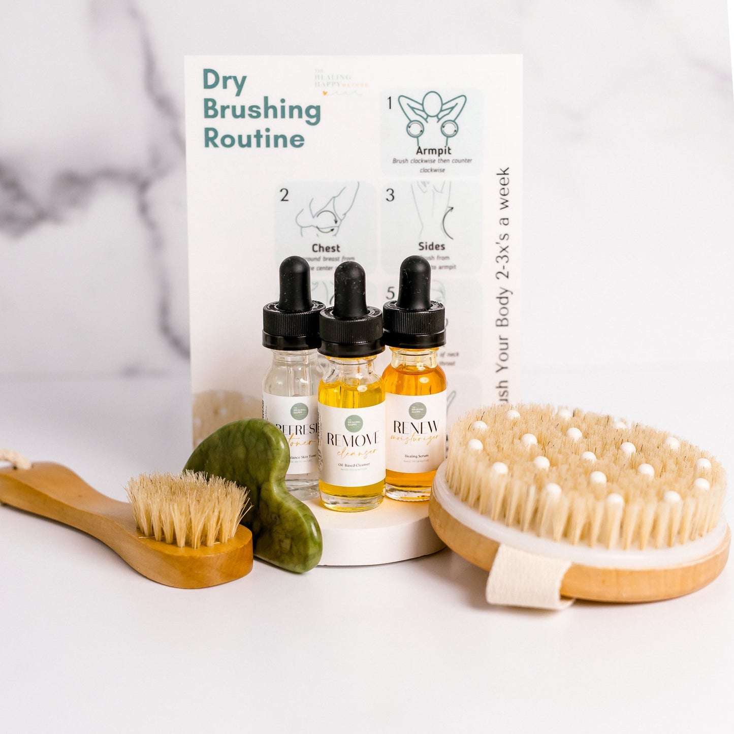 Dry brushing routine set with brushes, bottles, and a guide on a white background