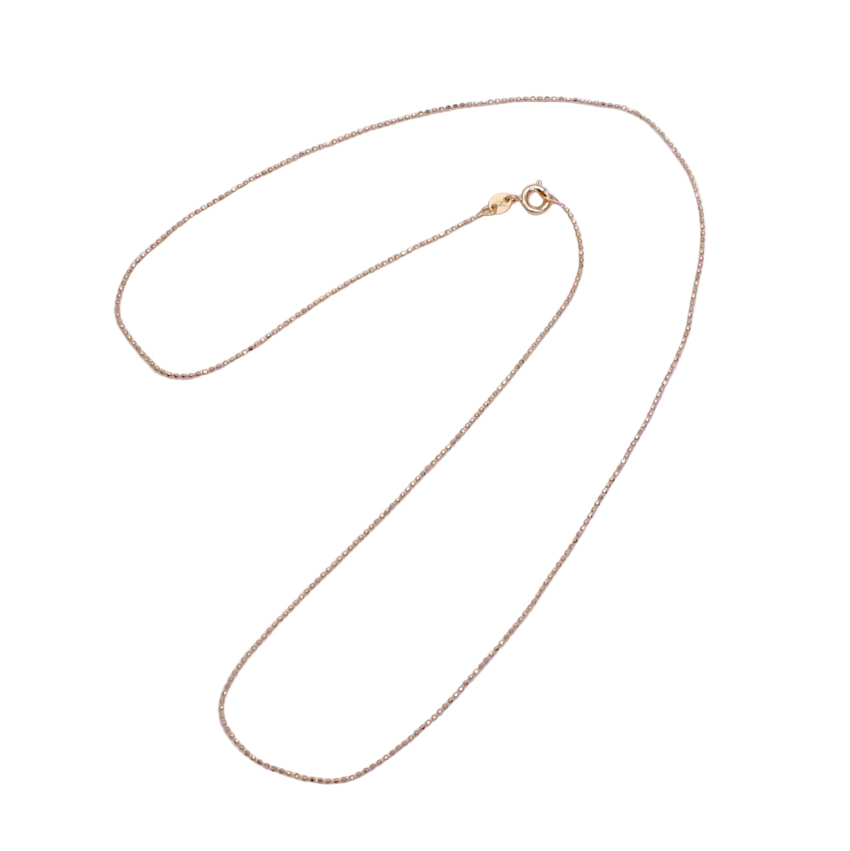 Gold chain necklace on a light purple background