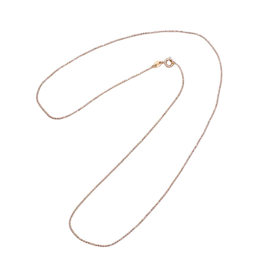 Gold chain necklace on a light purple background