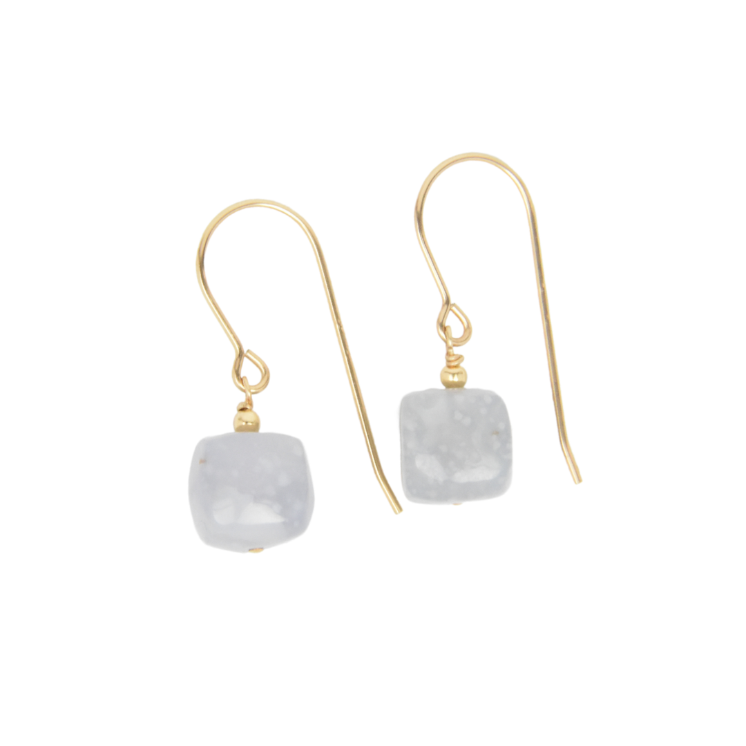 Gold earrings with square gray stones on a white background