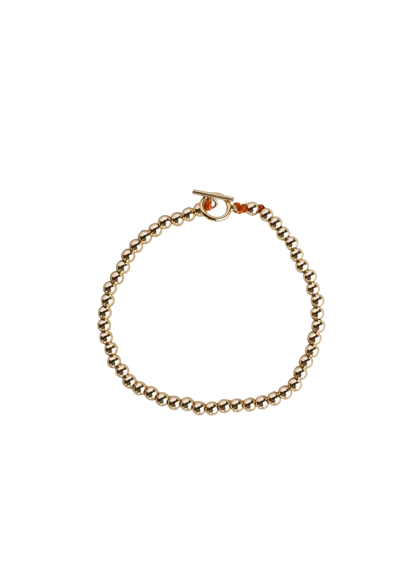 Gold bracelet on a light gray background