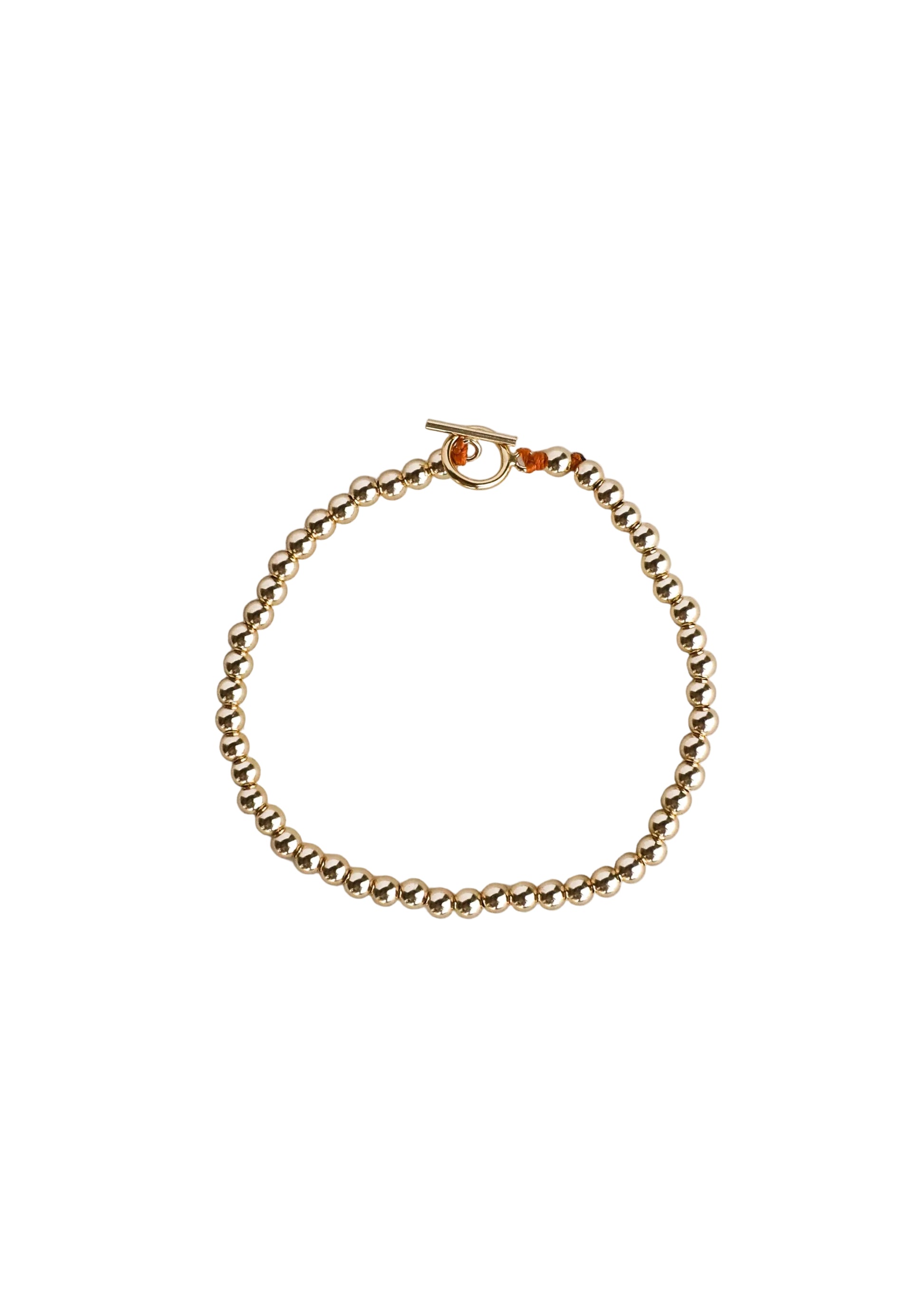 Gold bracelet on a light gray background