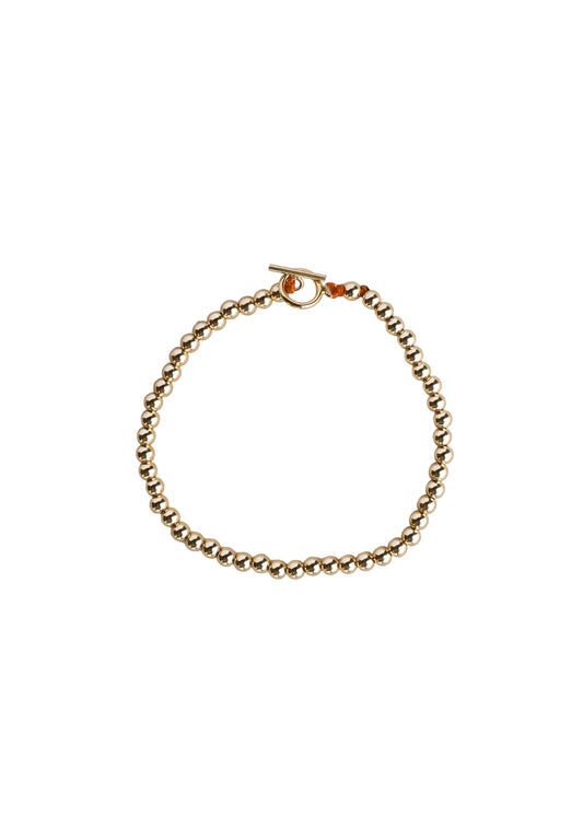 Gold bracelet on a light gray background