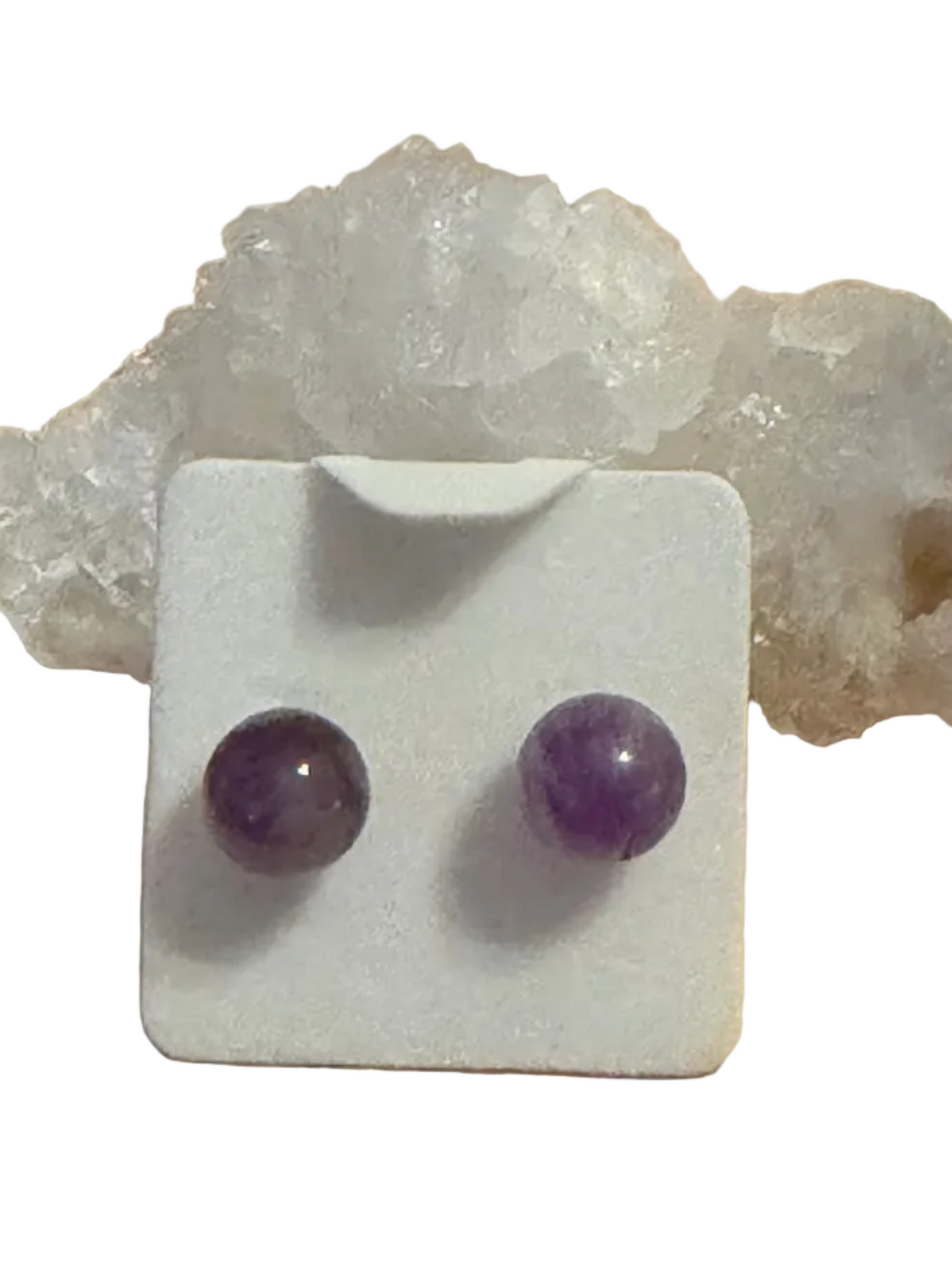 Amethyst stud earrings on a white card with a crystal background
