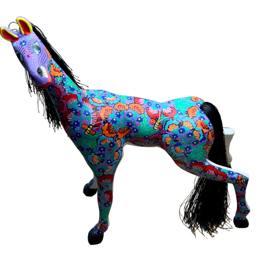 Colorful horse figurine with butterfly pattern on a wooden surface