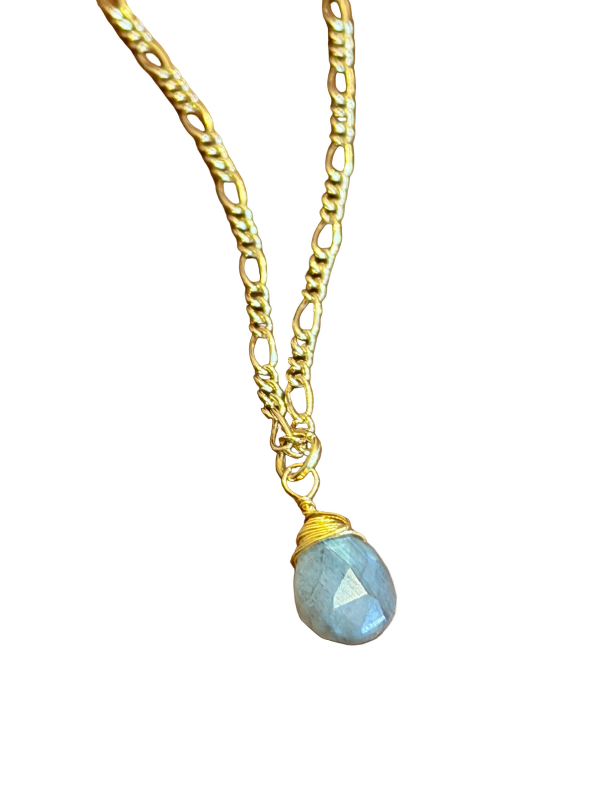 Necklace with a gold chain and blue gemstone on a wooden surface