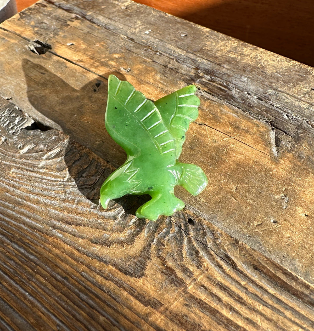 Green leaf-shaped object on a wooden surface