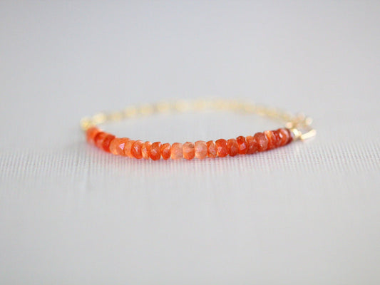Bracelet with orange beads on a light gray background