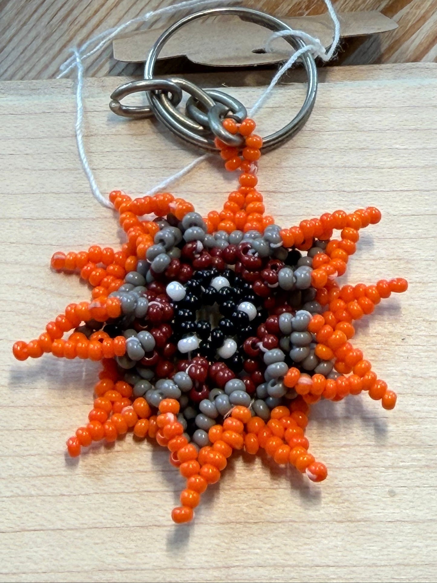 Flower-shaped orange/grey/red beaded keychain 