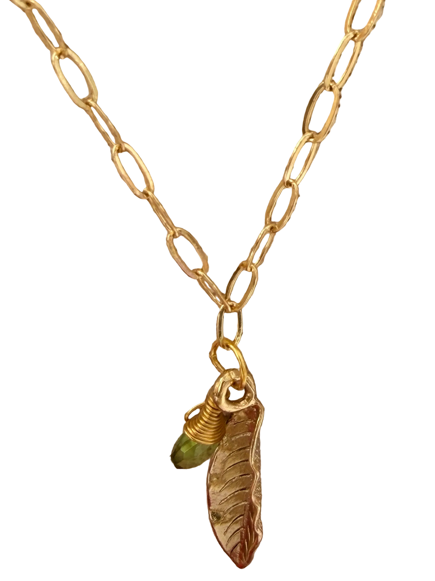 Gold necklace with a leaf-shaped pendant on a white background