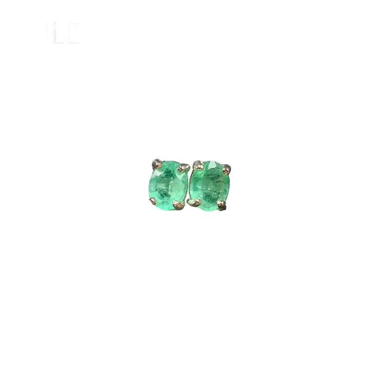 Pair of green gemstone earrings on a dark textured surface with 'YULEM' branding.