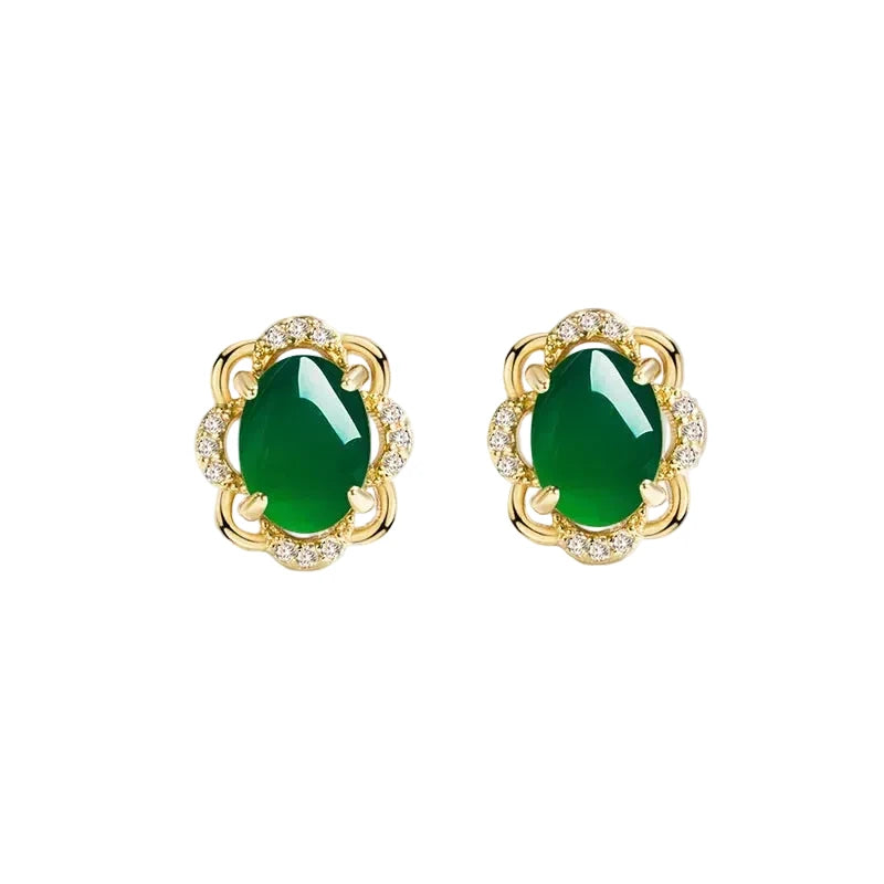Gold earrings with green gemstones on a white background
