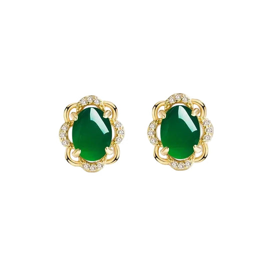 Gold earrings with green gemstones on a white background