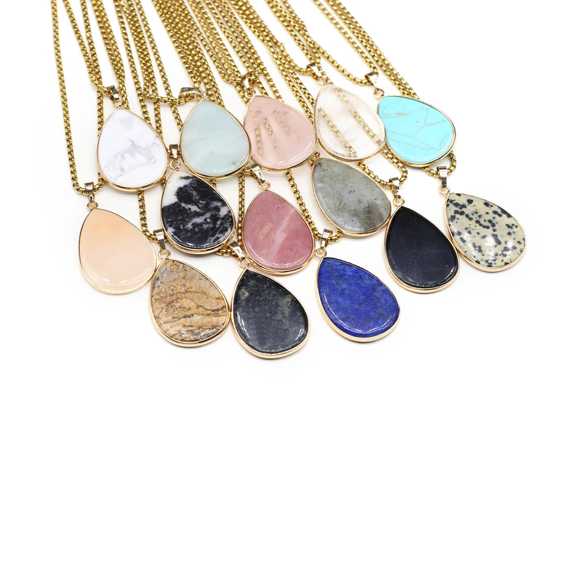 Necklaces with teardrop-shaped gemstones on gold chains against a white background