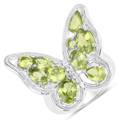 Butterfly-shaped ring with green gemstones on a white background